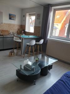 a living room with a glass table and chairs at appartement malo les bains plage in Dunkerque +10 photos