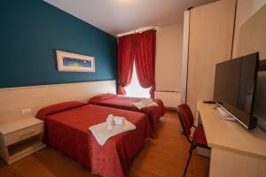 a hotel room with two beds and a flat screen tv at Hotel Break House Ristorante in Terranuova Bracciolini