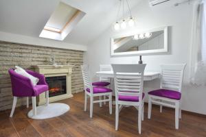 ein Esszimmer mit einem Tisch, Stühlen und einem Kamin in der Unterkunft Apartman Senka in Budva