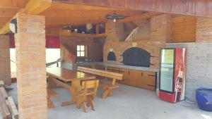 a kitchen with a wooden table and a pizza oven at Apartment ZEKO in Veliki Lovrečan