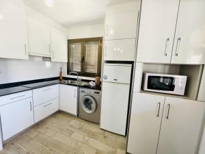 kuchnia z białymi szafkami i pralką i suszarką w obiekcie A46 - Atalaya - 2004 Finestrat s.l. w mieście Cala de Finestrat