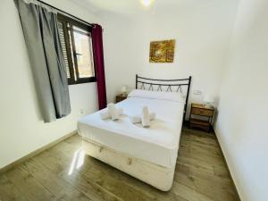 1 dormitorio con cama blanca y ventana en A46 - Atalaya - 2004 Finestrat s.l. en Cala de Finestrat