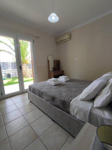 een slaapkamer met een bed en een glazen schuifdeur bij Konomi Residence-Marilena Apartment in Karavádhos