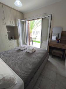 Konomi Residence-Marilena Apartment في Karavádhos: غرفة نوم عليها سرير وفوط