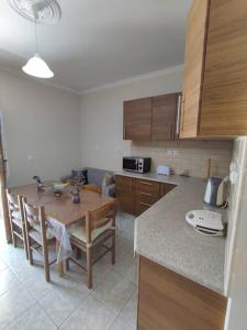 Konomi Residence-Marilena Apartment في Karavádhos: مطبخ مع طاولة خشبية وطاولة وكراسي