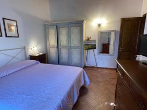 a bedroom with a bed and a dresser and a television at Casa Sophia con piscina - ingresso, giardino, barbecue e parcheggio privati by ToscanaTour in Guardistallo +27 photos
