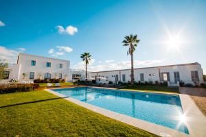 una piscina davanti a una casa con palme di Baglio Custera a Marsala