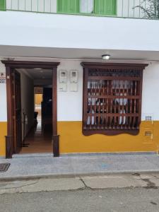 une porte menant à un bâtiment avec une étagère de bouteilles de vin dans l'établissement HOSPEDAJE EN ESPLENDOR, à Jardín