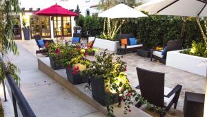 a patio with chairs and flowers and umbrellas at Hotel Marisol Coronado in San Diego