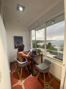 a man sitting at a desk with a laptop at Pargos Hotel & Cowork in Puerto Escondido