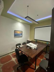 a conference room with a table and a white screen at Pargos Hotel & Cowork in Puerto Escondido
