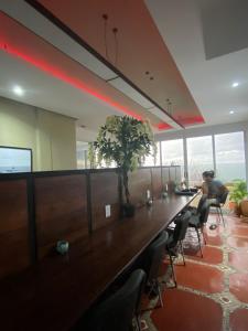 Pargos Hotel & Cowork في بويرتو إسكونديدو: رجل يجلس على طاولة طويلة في مكتب