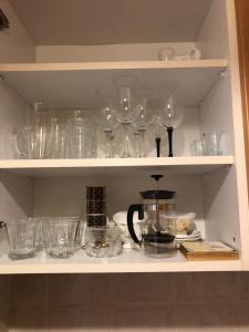 um armário cheio de copos e uma cafeteira em Britannica em Hévíz
