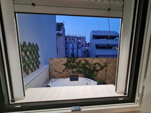 een raam met uitzicht op een gebouw bij Jenny's Dream Home -Acropolis Lux 2 Bedroom Apt, with Hot Tub, free Netflix, fast Wifi in Athene