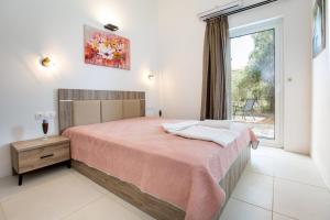 a bedroom with a large bed and a window at AVGOUSTIDIS APARTMENTS in Limenaria