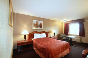 ein Hotelzimmer mit einem Bett und einem Stuhl in der Unterkunft Travel Inn & Suites Flemington in Flemington
