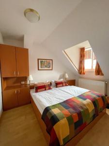 a bedroom with a bed with a colorful blanket at Altwernigeröder Apparthotel in Wernigerode