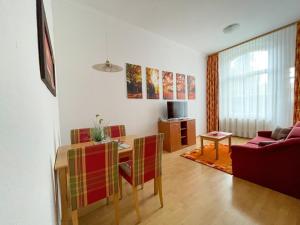 a living room with a table and a couch at Altwernigeröder Apparthotel in Wernigerode