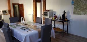 a dining room table with a white table and chairs at L'eau vive in Ranspach