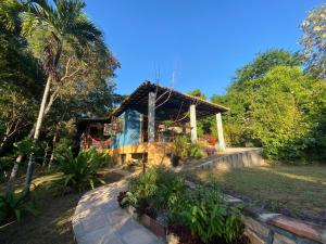 伦索伊斯Hospedagem do Sítio的花园中带茅草屋顶的房子