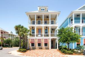 a large white building with a balcony on a street at House of Kings in Destin