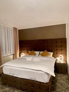 ein Schlafzimmer mit einem großen Bett mit zwei Leuchten in der Unterkunft Hotel Rüttenscheider Stern in Essen