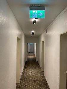einen langen Flur mit grünem Schild an der Decke in der Unterkunft Hotel Rüttenscheider Stern in Essen