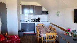 ヴァルマニエにあるAppartement cosy à Valmeinier avec vue montagne et piscineの部屋にテーブルと椅子のあるキッチン +13枚の写真