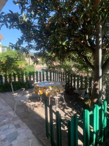 un tavolo e sedie sotto un albero accanto a una recinzione di Casa Vacanza Aventino a Taranta Peligna