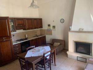 une cuisine avec une table à manger et une cheminée dans l'établissement Casa Vacanza Aventino, à Taranta Peligna