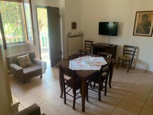 una sala da pranzo con tavolo, sedie e TV di Casa Vacanza Aventino a Taranta Peligna