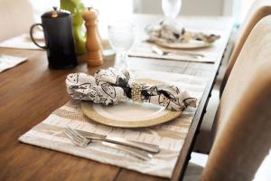 a dining room table with a plate and silverware at The New Brunswick Bed and Breakfast in Saint Andrews
