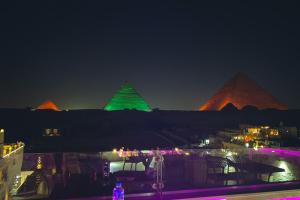 een zicht op de piramides van Giza 's nachts bij Giza Pyramids Inn in Caïro