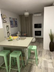 a kitchen with a sink and two green stools at Loft Barbate in Barbate +8 photos