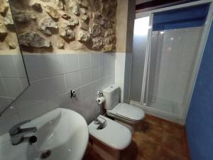 La salle de bains est pourvue d'un lavabo, de toilettes et d'une fenêtre. dans l'établissement Casa Alta, à Valderrobres