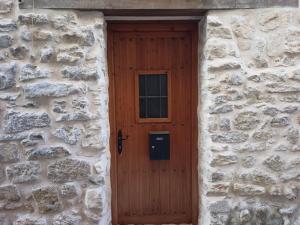 - une porte en bois dans un bâtiment en pierre avec une fenêtre dans l'établissement Casa Alta, à Valderrobres