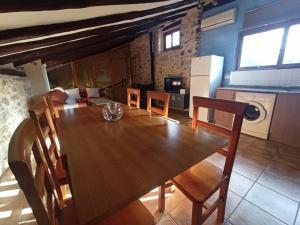 Il comprend une cuisine et une salle à manger avec une table et des chaises en bois. dans l'établissement Casa Alta, à Valderrobres
