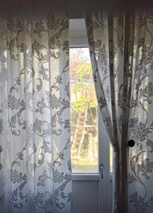 a window with curtains in a room with a tree at Casa Bella in Ponti Sul Mincio