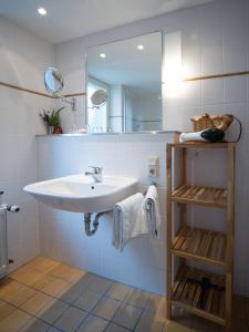 ein weißes Badezimmer mit einem Waschbecken und einem Spiegel in der Unterkunft Gästehaus Stadtmitte in Merzig