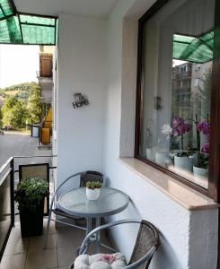 a table and chairs on a balcony with a window at Joy Apartman in Sovata