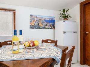 stół jadalny z 2 butelkami i miską owoców w obiekcie Il Sogno di Lorna w Sorrento