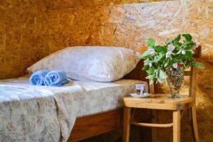 ein Schlafzimmer mit einem Bett und einem Tisch mit einer Blumenvase in der Unterkunft Grandma's Hut in Nikšić