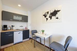 eine Küche mit Tisch und Stühlen in einem Zimmer in der Unterkunft Vienna Lights Apartments - Hernals in Wien