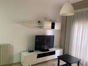 ein Wohnzimmer mit einem Flachbild-TV auf einem weißen Entertainment-Center in der Unterkunft alojamientosteruelmarqueses El Marqués in Teruel