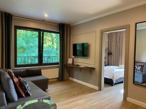 un soggiorno con divano, letto e finestra di Oasis Resort & Spa a Rewal
