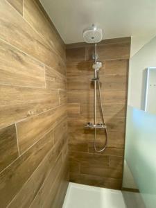 y baño con ducha y paredes de madera. en Luxury apartment "Volmolen" with garden, terrace and free parking, en Harelbeke