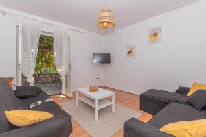 ein Wohnzimmer mit 2 Sofas und einem Tisch in der Unterkunft Apartment Nocturno in Rogoznica