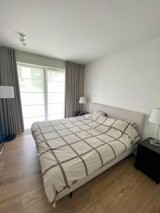 um quarto com uma cama grande e uma janela grande em Luxury apartment "Volmolen" with garden, terrace and free parking em Harelbeke