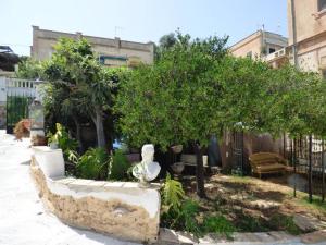 eine Statue auf einer Bank neben Bäumen in der Unterkunft Relais dei Mori Home Palermo in Casteldaccia