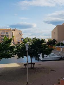 a street light sitting next to a bench next to a river at La Galiote, T2 vue port, terrasse et parking in Frontignan